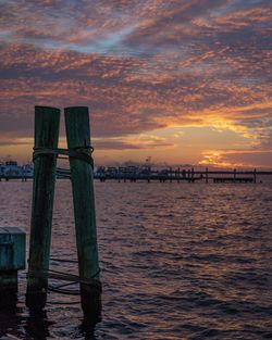 Pier over sea against sky during sunset