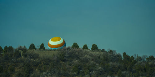 Yellow balloons on field against clear blue sky