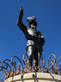 Low angle view of statue against blue sky