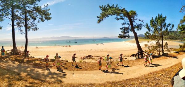 Group of people on beach against sky