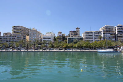 Buildings by swimming pool against blue sky