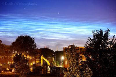 Illuminated buildings against sky at night