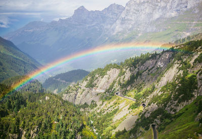 Scenic view of rainbow over mountain against sky