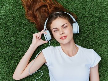 Portrait of young woman sitting on grassy field