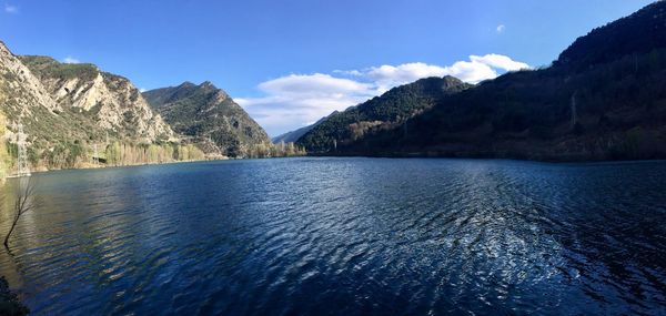 Scenic view of lake and mountains against blue sky