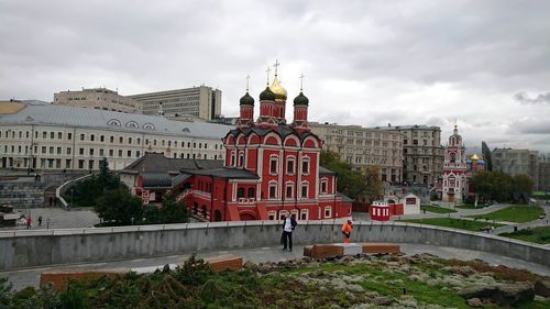 Buildings in city against cloudy sky