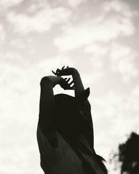 Close-up of man hand against sky