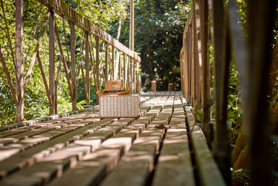 Surface level of sun hat and bag on wooden footbridge