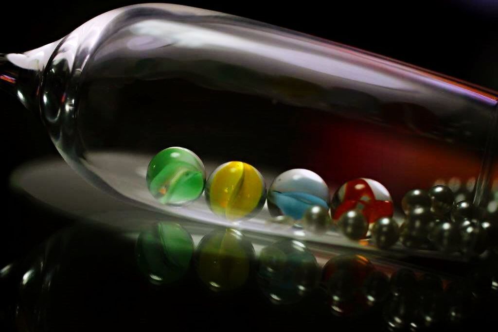 indoors, still life, close-up, multi colored, food and drink, glass - material, variation, large group of objects, studio shot, black background, transparent, choice, bottle, table, no people, drinking glass, illuminated, colorful, container, reflection