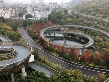 High angle view of footbridge over trees in city