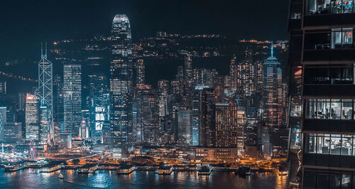 Illuminated buildings in city against sky at night