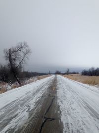 Snow covered road against clear sky