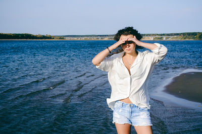 Full length of young woman standing in sea