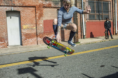 Young woman performing an ollie on skateboard