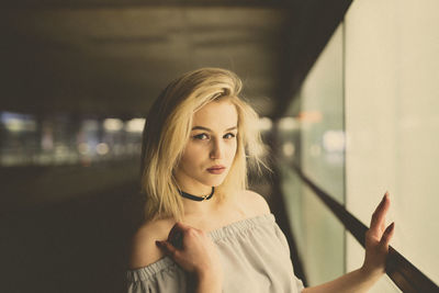 Portrait of young woman by window