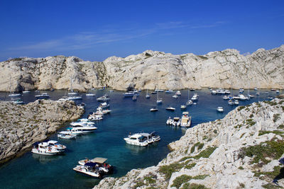 High angle view of sailboats by sea against blue sky