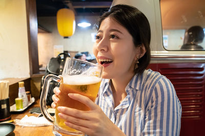 Portrait of woman drinking glass in restaurant