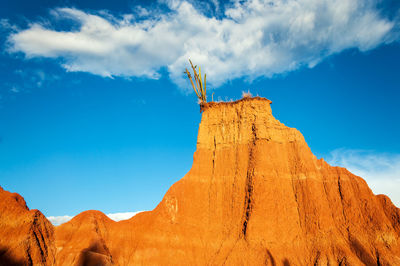 Low angle view of rock formations at tatacoa desert against blue sky