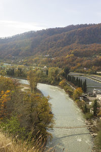 Scenic view of river by mountains against sky