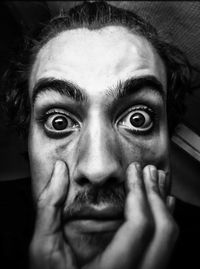 Close-up portrait of young man holding his face