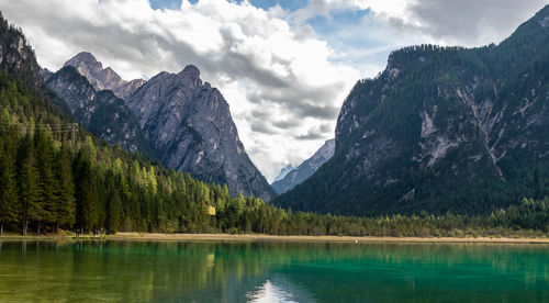 Scenic view of lake by mountains against sky