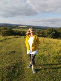 Full length of woman standing on grass against sky