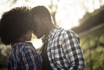 Close-up of loving couple at park on sunny day