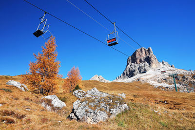 Low angle view of overhead cable car against sky