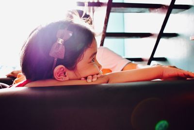 Close-up of girl lying on car