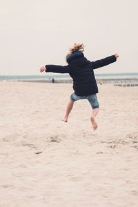 Full length of man jumping on beach