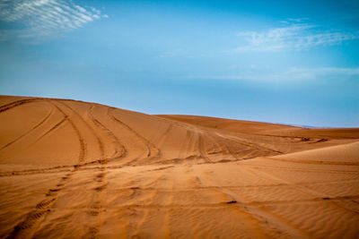 Scenic view of desert against blue sky