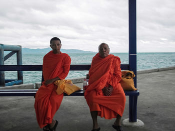 Portrait of men standing on beach against sky