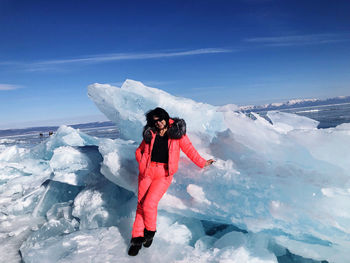 Portrait of woman standing by ice against sky