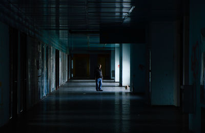 Rear view of man walking in corridor of building