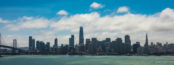 Panoramic view of city buildings against cloudy sky