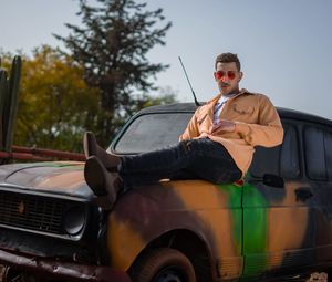 Side view of man sitting in car