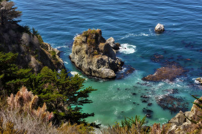 High angle view of rock formation in sea against sky