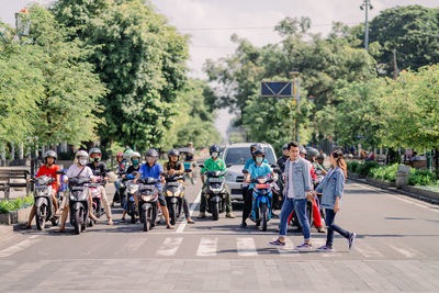 Group of people sitting on street in park