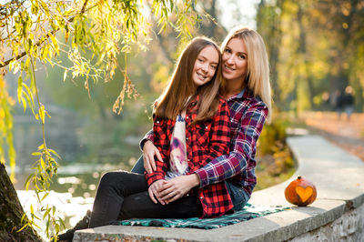 Portrait of smiling young woman sitting outdoors