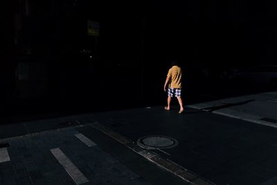 Woman standing on road at night