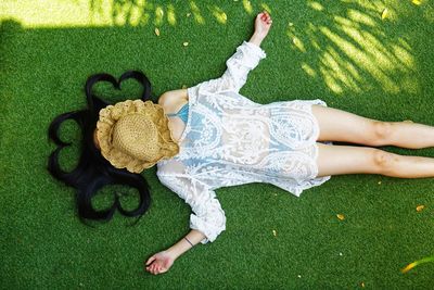 High angle view of woman lying on grassy field