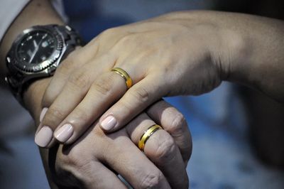 Cropped image of couple showing wedding rings