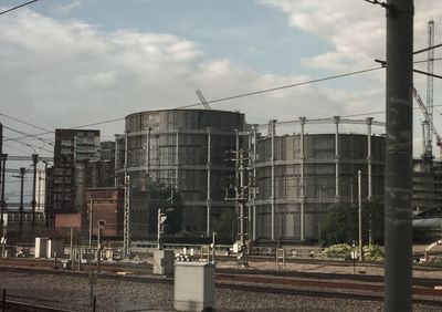 Railroad tracks by buildings against sky