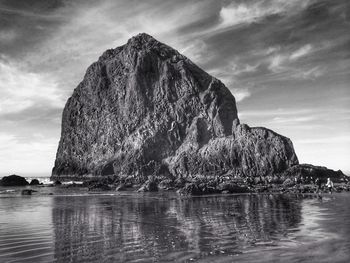 Rock formations by sea against sky