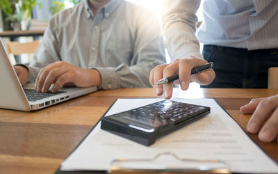 Midsection of man using laptop on table