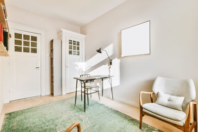 Empty chairs and table against wall at home