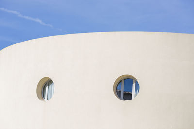 Low angle view of building windows against sky