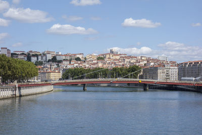Bridge over river in town against sky