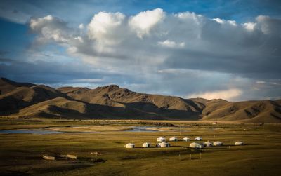 Scenic view of field and mountains against sky