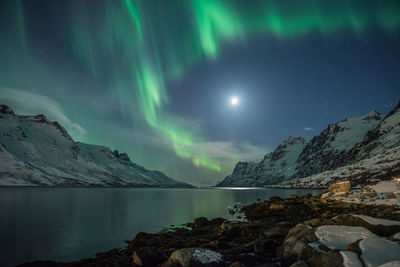 Scenic view of lake and mountains against sky at night